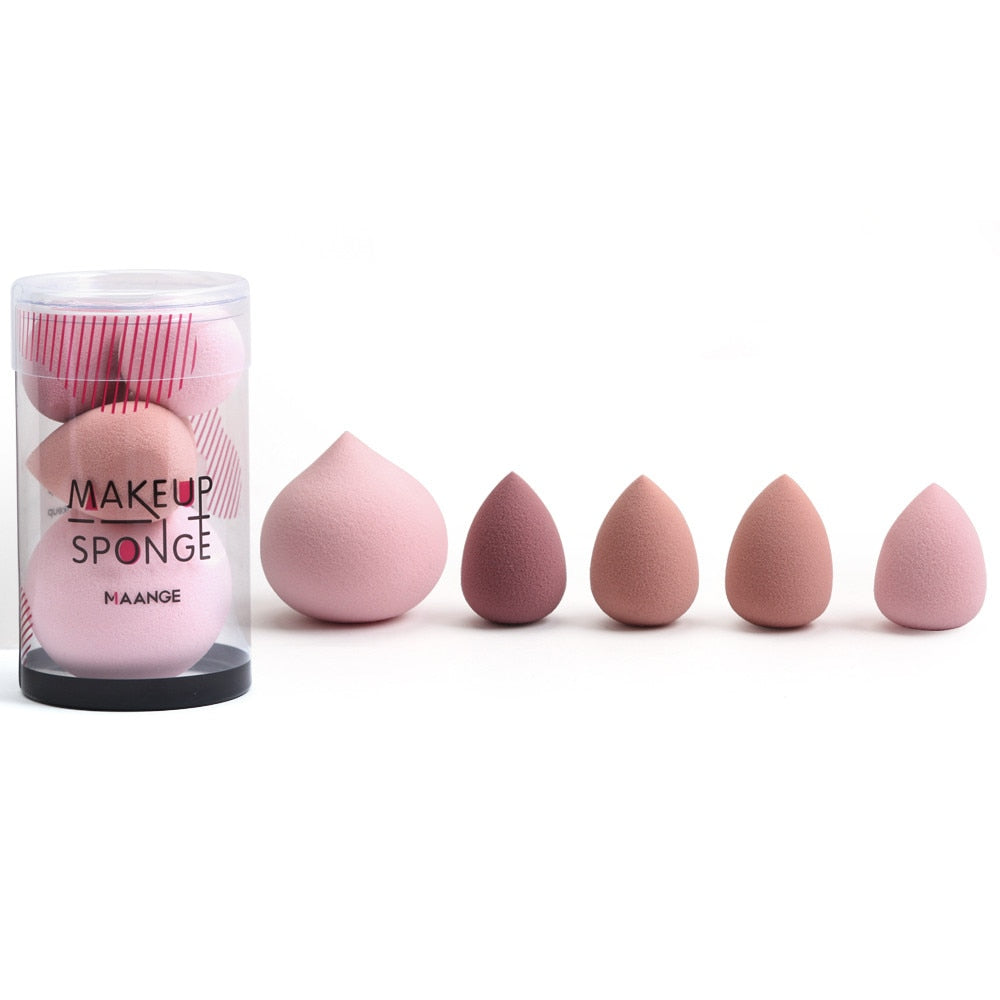 Set of pink teardrop-shaped makeup sponges in a clear container and arranged in a row.
