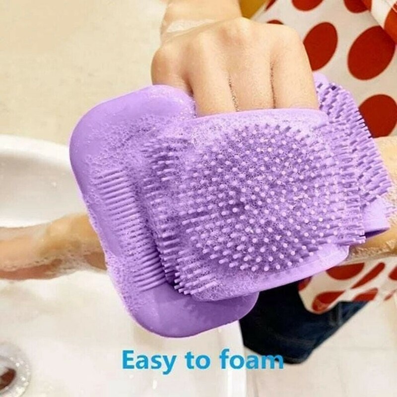 Hand holding foaming purple silicone body brush
