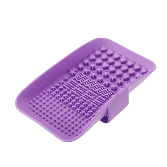 Purple silicone foot scrubber with various textured massage nodes and a suction cup base