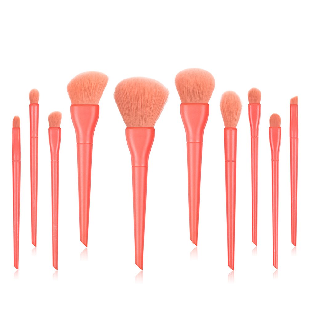 Set of 11 professional makeup brushes with pink bristles and matching coral handles
