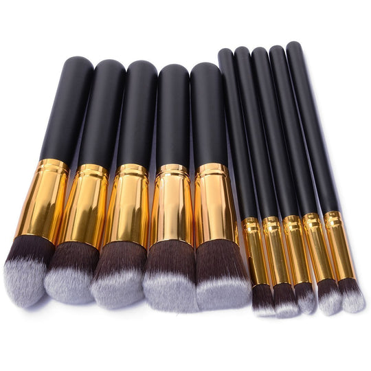 Set of professional makeup brushes with black handles and gold ferrules.