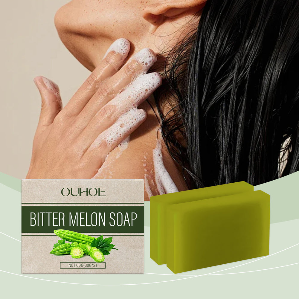 Hand lathering bitter melon soap on shoulder with product box