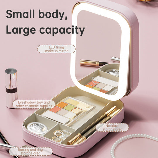 Pink compact LED makeup mirror with eyeshadow tray and jewelry storage compartments.